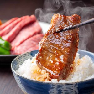 温かいご飯と焼肉を一緒に食べるシーン