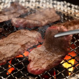 meat on a grill with a tong